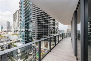 A high-rise balcony with a glass railing overlooks a dense urban cityscape — 45 SW 9th St # 1701, Miami FL 33130, MIAMI, FL