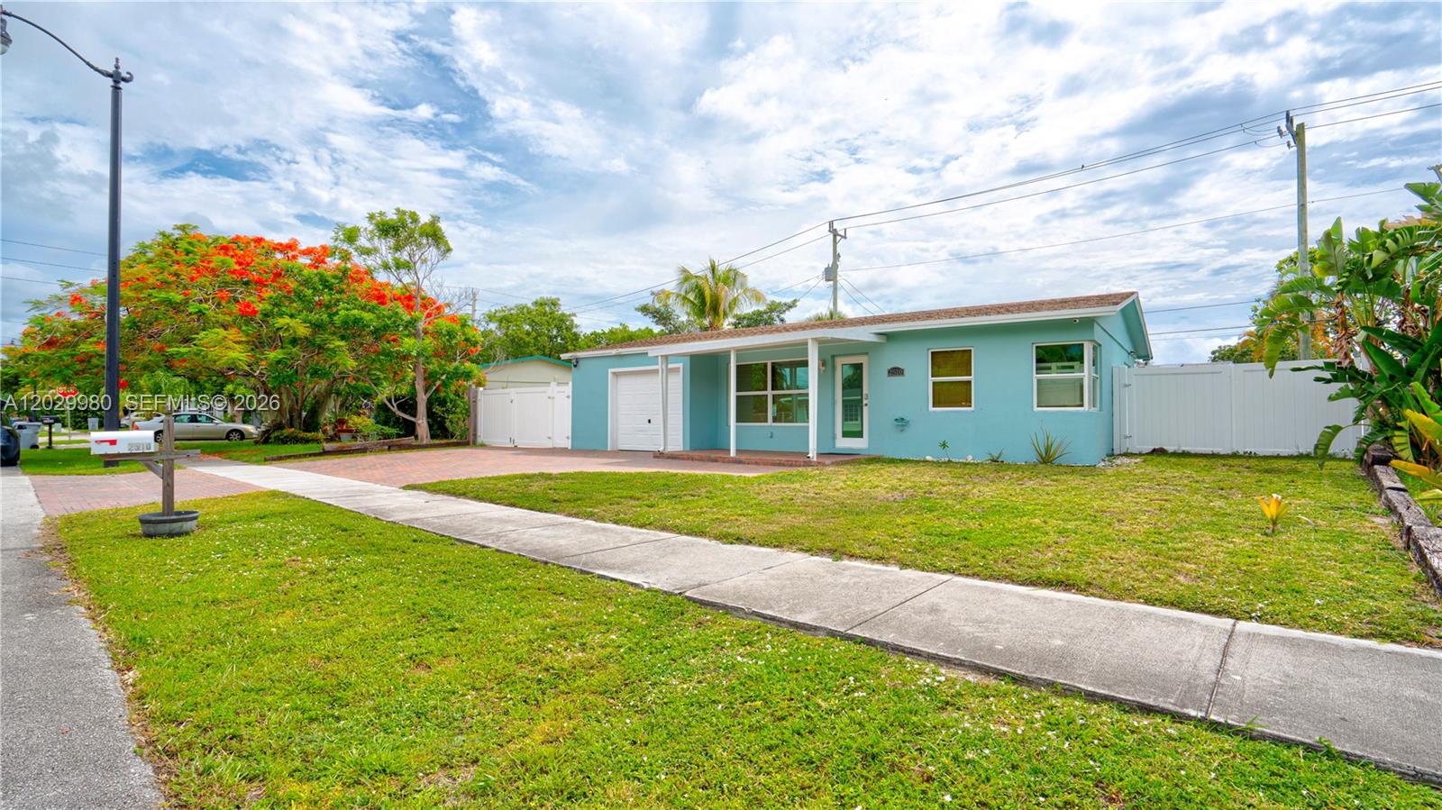 A single-story light blue house with a paved driveway and a front lawn — 2510 NE 9th Ave, Pompano Beach FL 33064, POMPANO BEACH, FL