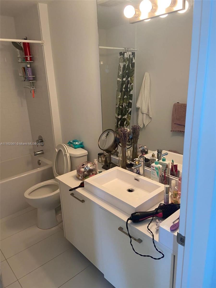 A bathroom features a white vessel sink, a toilet, and a shower-tub combination — 151 SE 1st St, Miami FL 33131, MIAMI, FL
