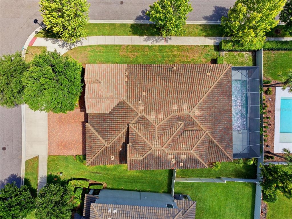 An aerial view shows a house with a tiled roof, a pool enclosure, and landscaping — 2451 SLADE AVENUE, ODESSA, FL