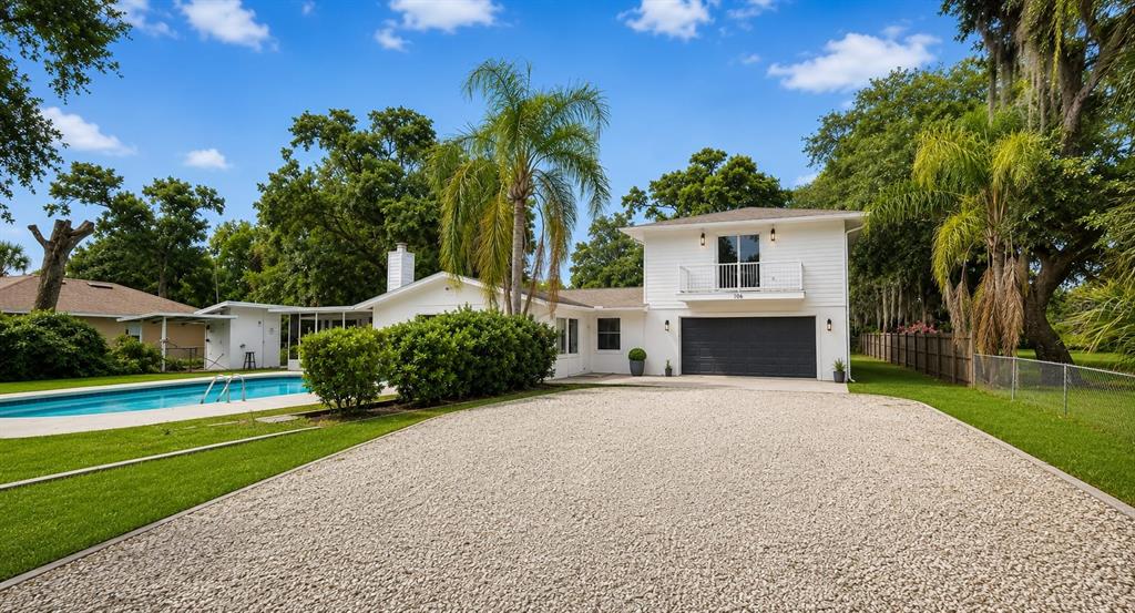 A white house with a swimming pool and a large green lawn under a blue sky — 1080 LANDERS STREET, ORMOND BEACH, FL