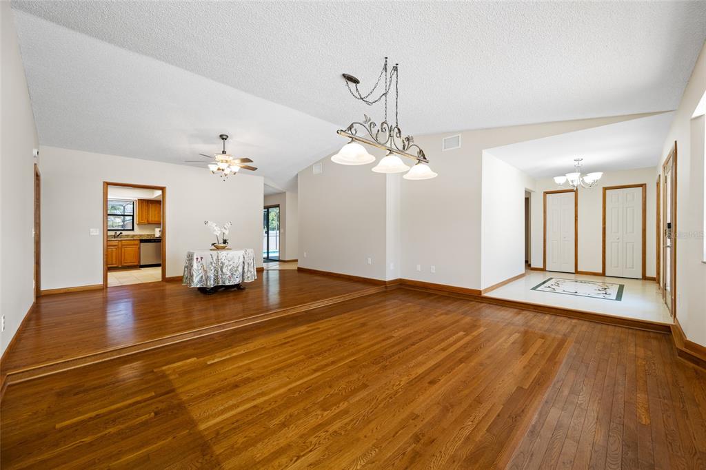 A spacious living area features hardwood floors, a sunken dining space, and two light fixtures — 2409 OSPREY AVENUE, PALM HARBOR, FL