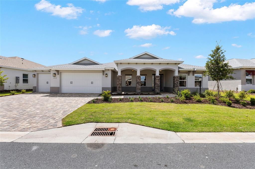 A single-story house with a paved driveway, three-car garage, and a covered front porch — 8512 SW 101ST AVENUE, OCALA, FL