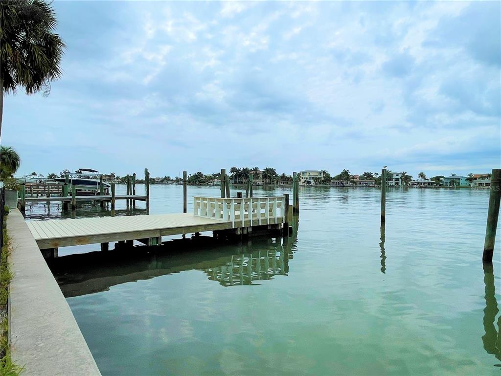 A gray, single-story house with a white garage door and a cracked concrete driveway — 17045 DOLPHIN DRIVE, NORTH REDINGTON BEACH, FL