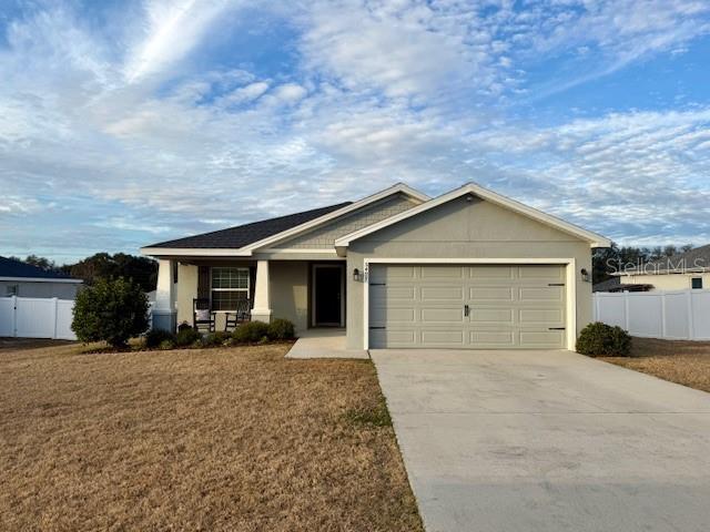 A single-story house with a two-car garage, a front porch, and a concrete driveway — 5497 SE 91ST PLACE, OCALA, FL