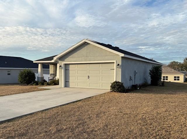 A single-story house with a light-colored stucco exterior and a two-car garage — 5497 SE 91ST PLACE, OCALA, FL