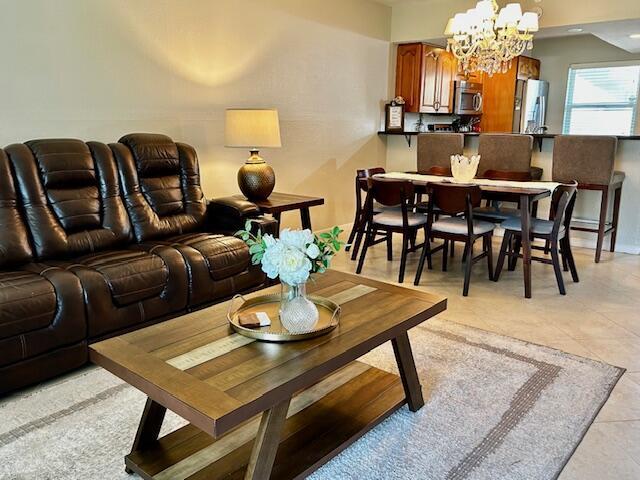 A living room with a brown leather sofa, wooden coffee table, and adjacent dining area — 550 NW 78th Terrace # 107, Margate FL 33063, MARGATE, FL