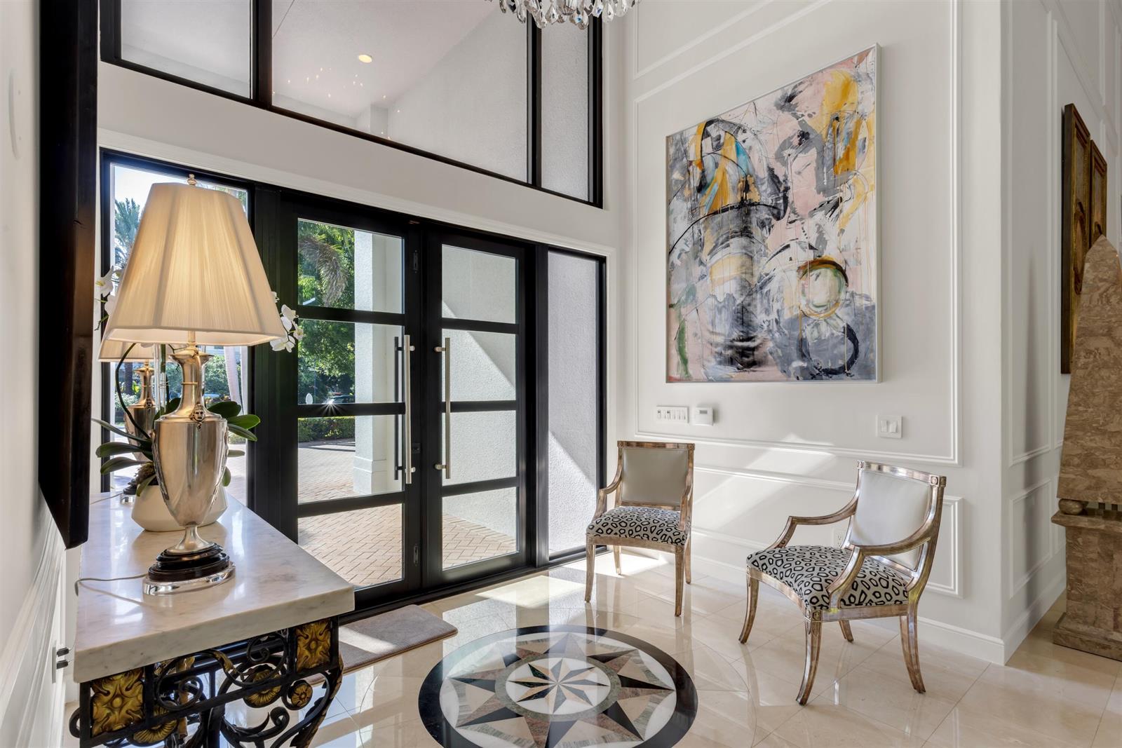 A bright foyer features a marble-topped console table, two patterned chairs, and a glass-paneled door — 4275 Sanctuary Lane, Boca Raton FL 33431, BOCA RATON, FL
