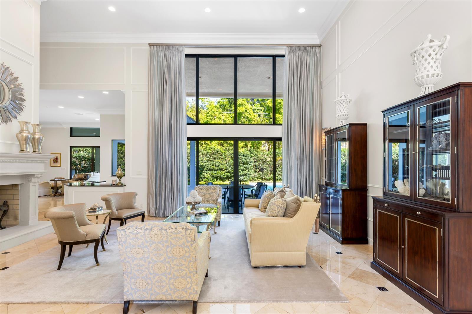 A formal living room features high ceilings, large windows, and a fireplace with tile flooring — 4275 Sanctuary Lane, Boca Raton FL 33431, BOCA RATON, FL