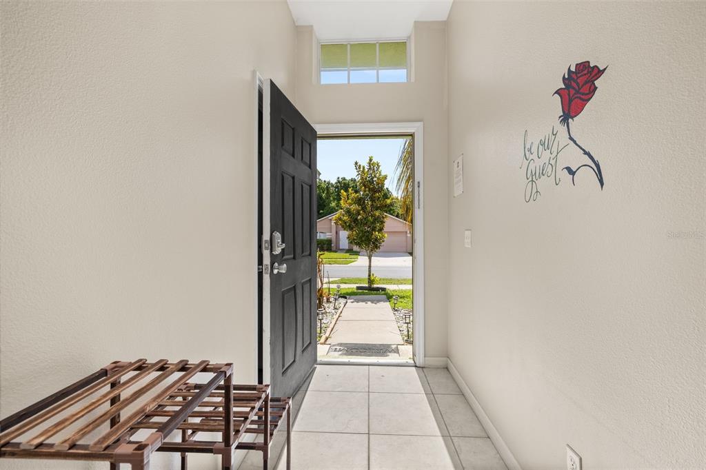 An entryway with tile flooring, a black front door, and a wall decal of a rose — 756 SCRUB JAY WAY, DAVENPORT, FL