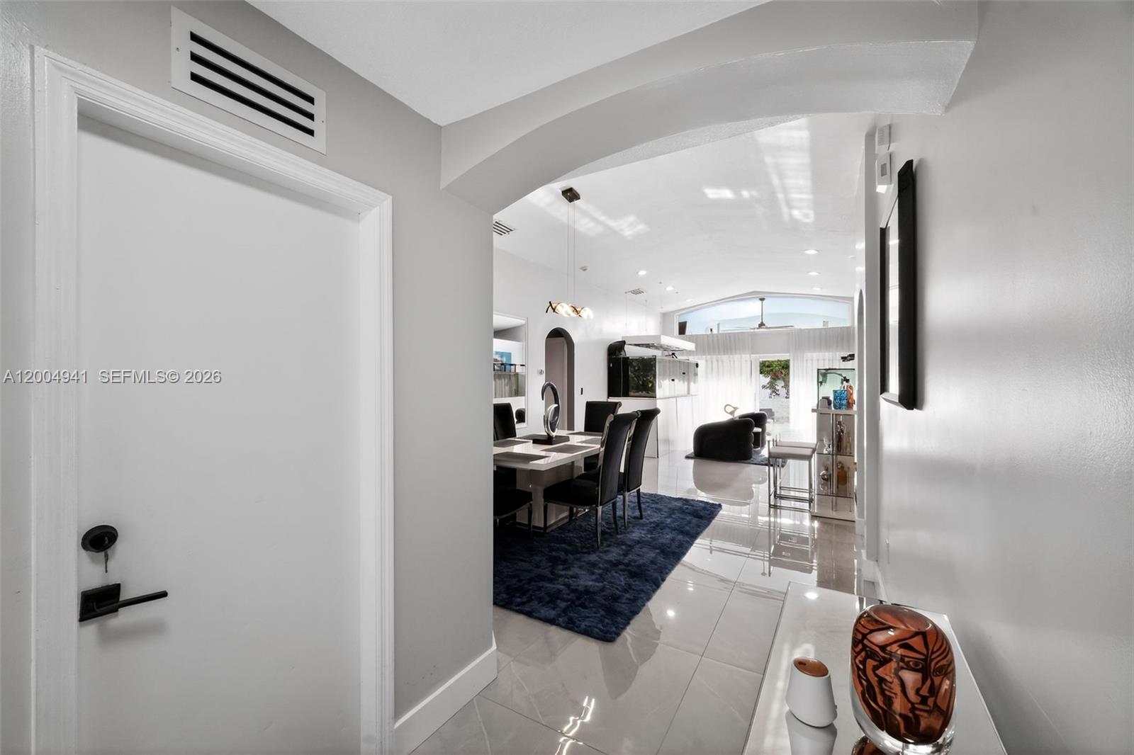 A white door opens into a dining area with a blue rug and tiled floors — 14471 SW 136th Pl, Miami FL 33186, MIAMI, FL