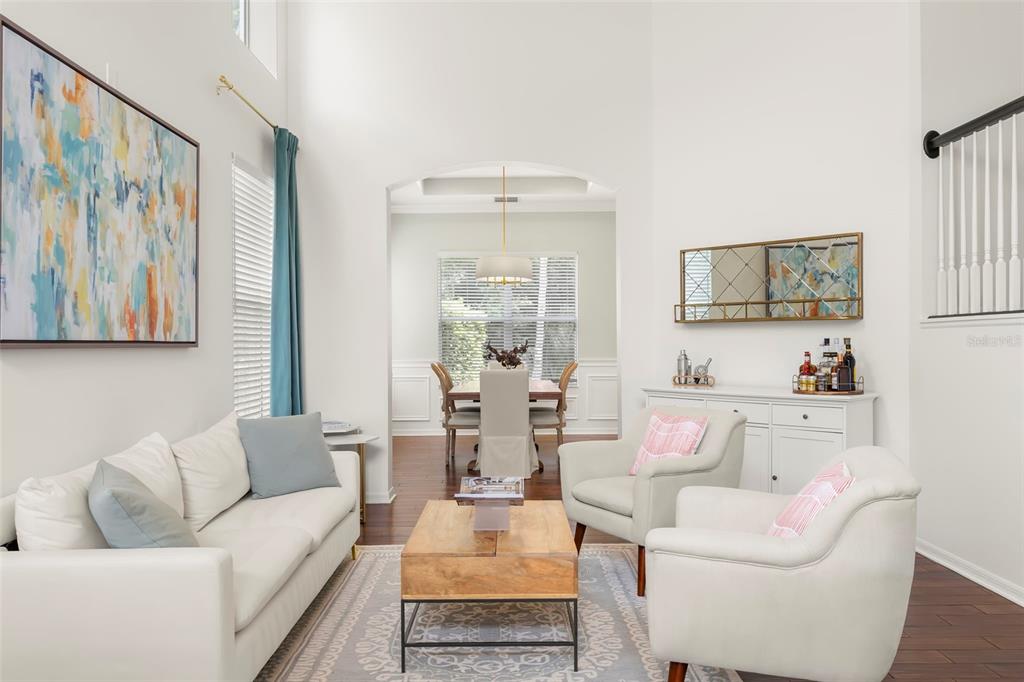 A bright kitchen features white cabinetry, a marble-topped island, stainless steel appliances, and gold hardware — 9706 GRETNA GREEN DRIVE, TAMPA, FL