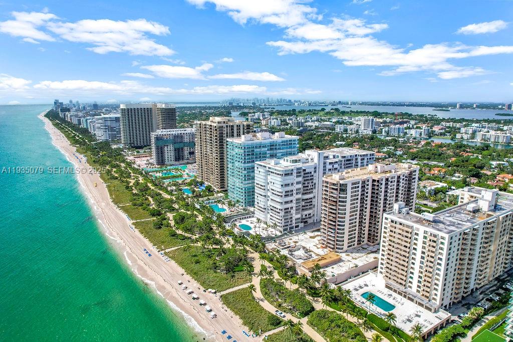 An aerial view shows high-rise residential buildings situated along a sandy beach and ocean — 10155 Collins Ave # 1106, Bal Harbour FL 33154, BAL HARBOUR, FL