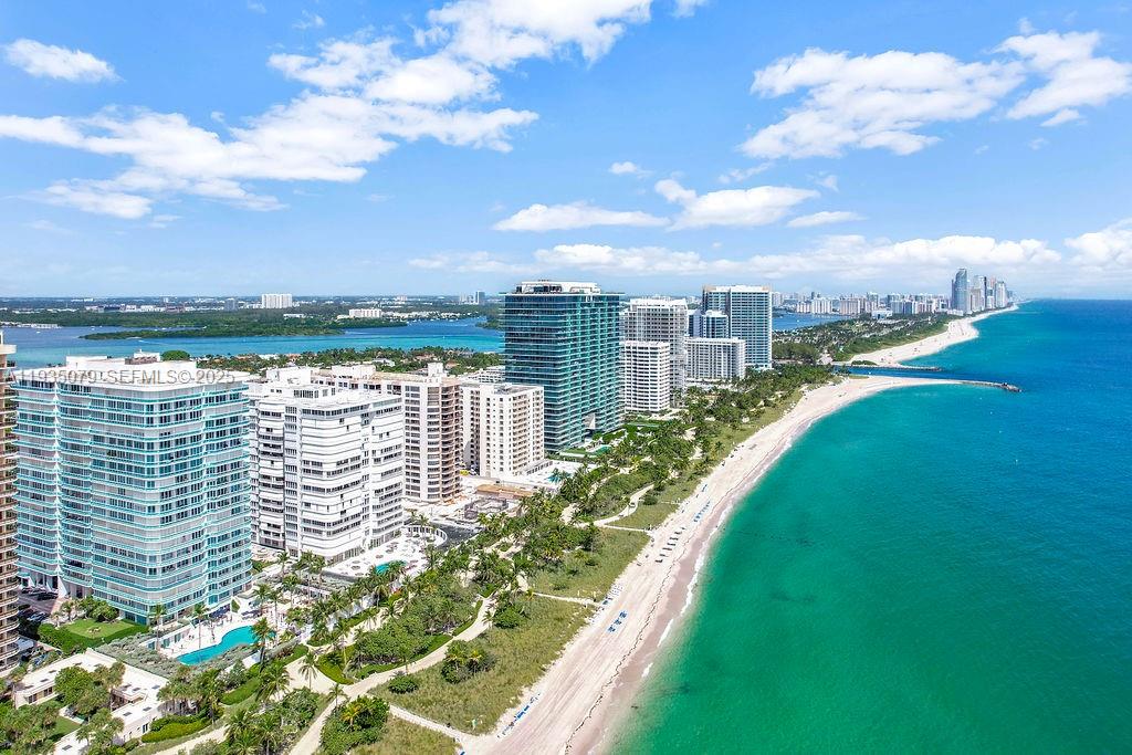 An aerial view shows high-rise residential buildings situated along a sandy beach and ocean — 10155 Collins Ave # 1106, Bal Harbour FL 33154, BAL HARBOUR, FL