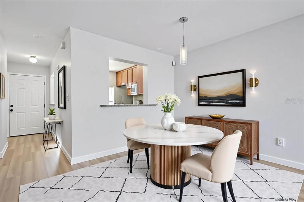 A dining area features a round marble table, two chairs, and a wooden sideboard — 9513 DARIEN AVENUE UNIT 9513, ORLANDO, FL