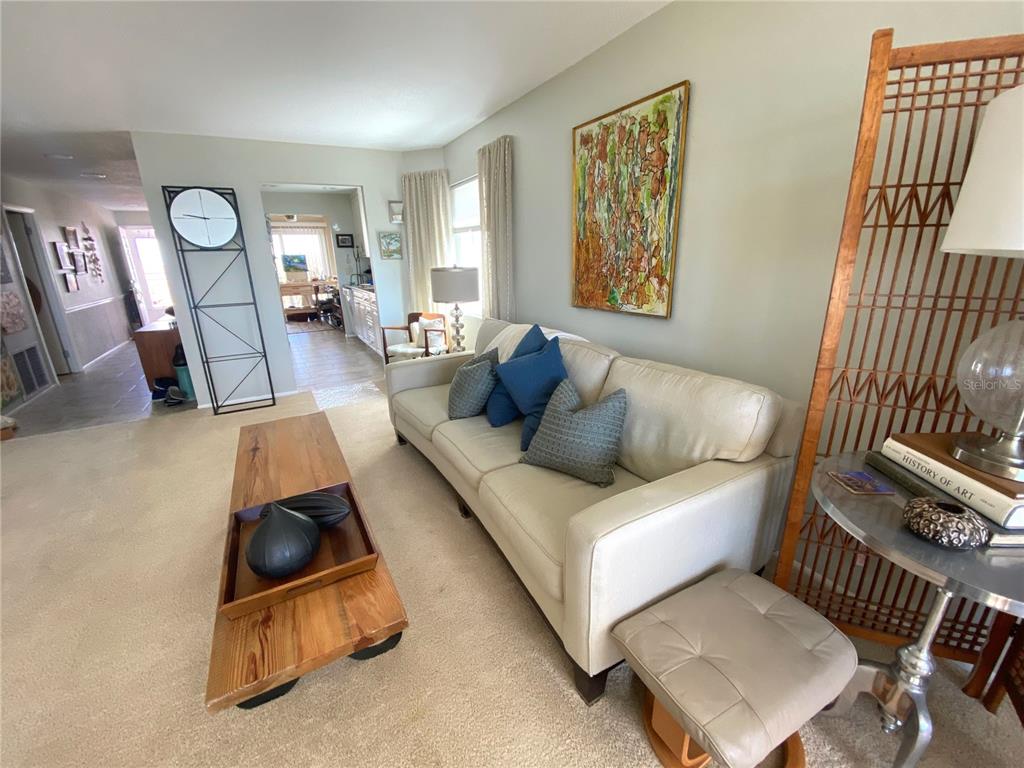 A living room features a beige sofa, a wooden coffee table, and a decorative screen — 500 THE ESPLANADE N UNIT 405, VENICE, FL