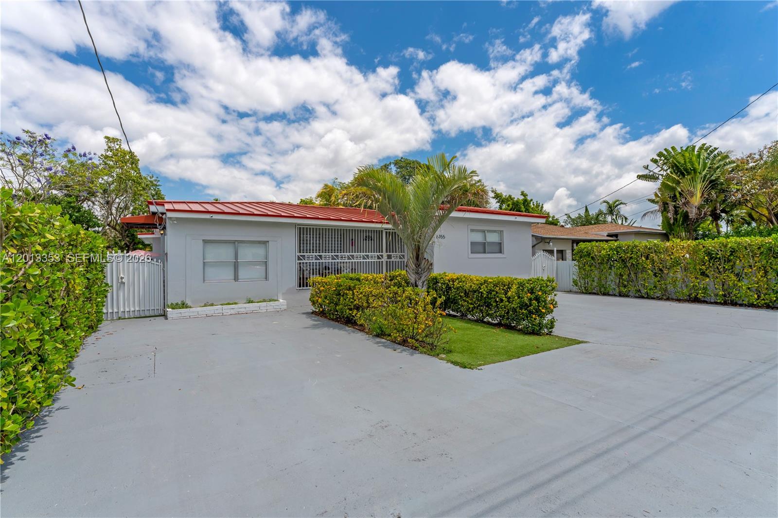 A single-story house with a red metal roof and a large concrete driveway — 6355 SW 30th St, Miami FL 33155, MIAMI, FL