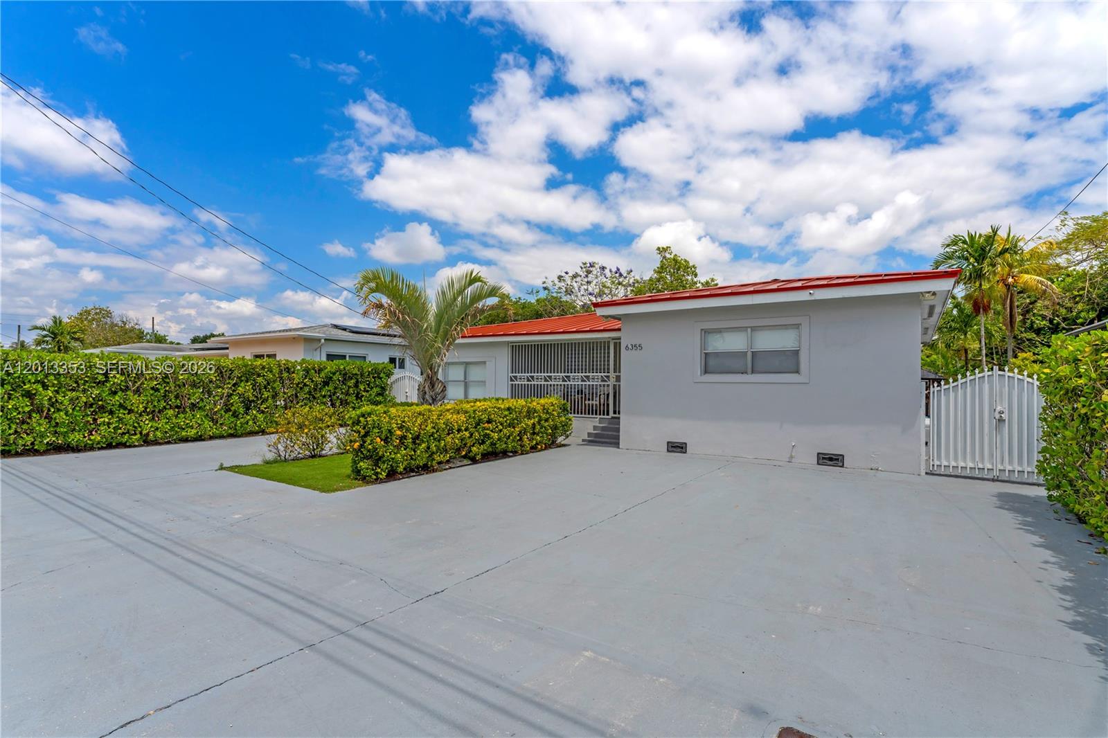 A single-story house with a gray exterior, red roof, and a large concrete driveway — 6355 SW 30th St, Miami FL 33155, MIAMI, FL