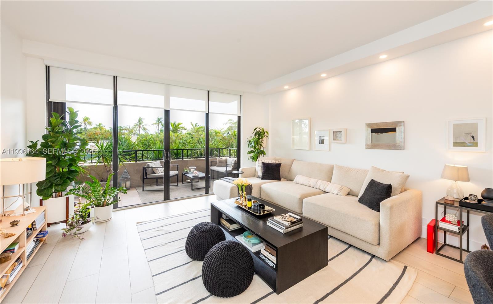 A modern living room features a beige sectional sofa, dark coffee table, and balcony access — 151 Crandon Blvd # 241, Key Biscayne FL 33149, KEY BISCAYNE, FL