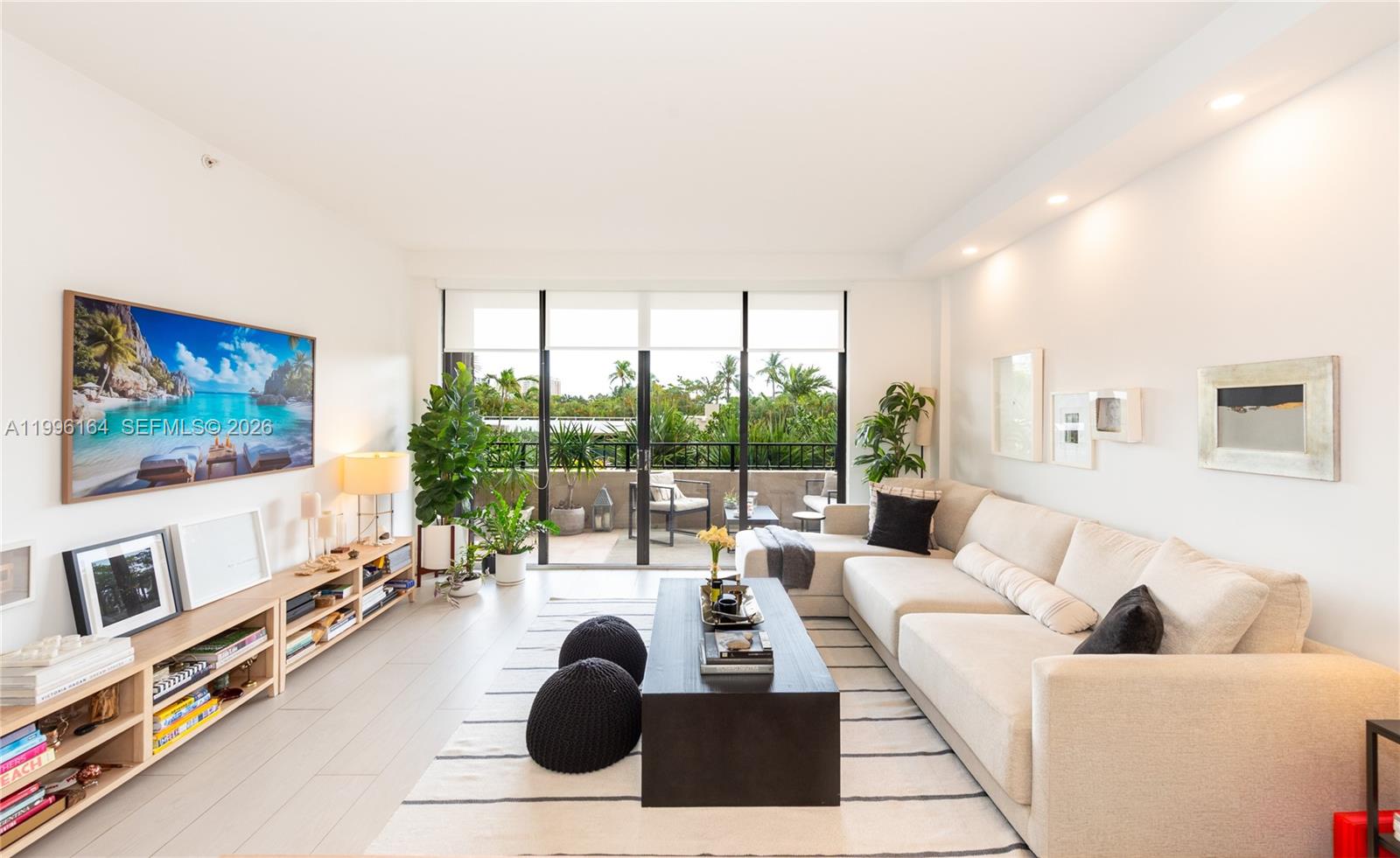 A bright living room features a sectional sofa, a coffee table, and a balcony view — 151 Crandon Blvd # 241, Key Biscayne FL 33149, KEY BISCAYNE, FL