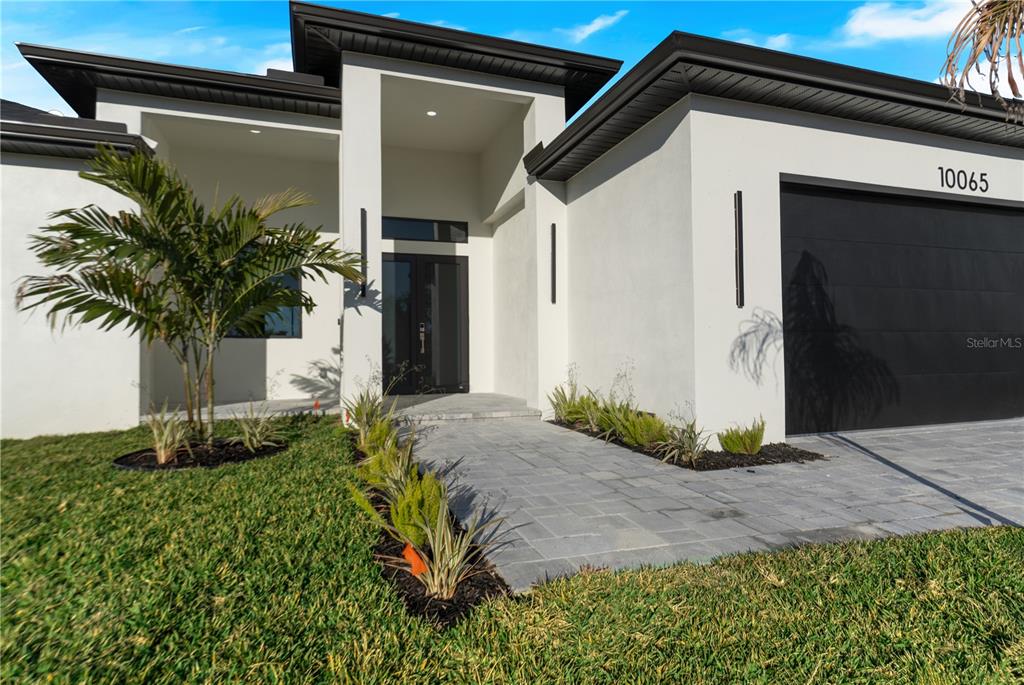 A modern kitchen features a large island, white cabinetry, stainless steel appliances, and tile flooring — 10065 MEMPHIS STREET, PORT CHARLOTTE, FL