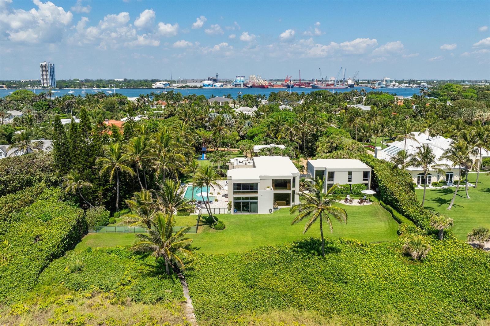 An aerial view shows a modern white house with a pool surrounded by lush landscaping — 1446 N Ocean Boulevard, Palm Beach FL 33480, PALM BEACH, FL