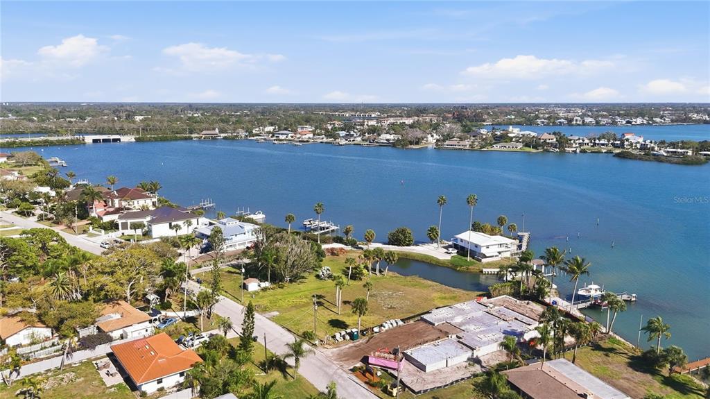An aerial view shows waterfront homes, a construction site, and a canal along the bay — 0 BAYVIEW PARKWAY, NOKOMIS, FL