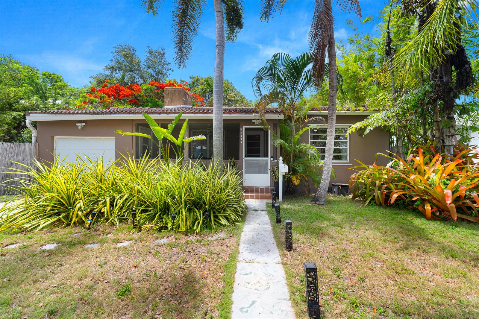 A single-story house with a brown exterior, a screened front porch, and lush tropical landscaping — 1535 Dewey Street, Hollywood FL 33020, HOLLYWOOD, FL