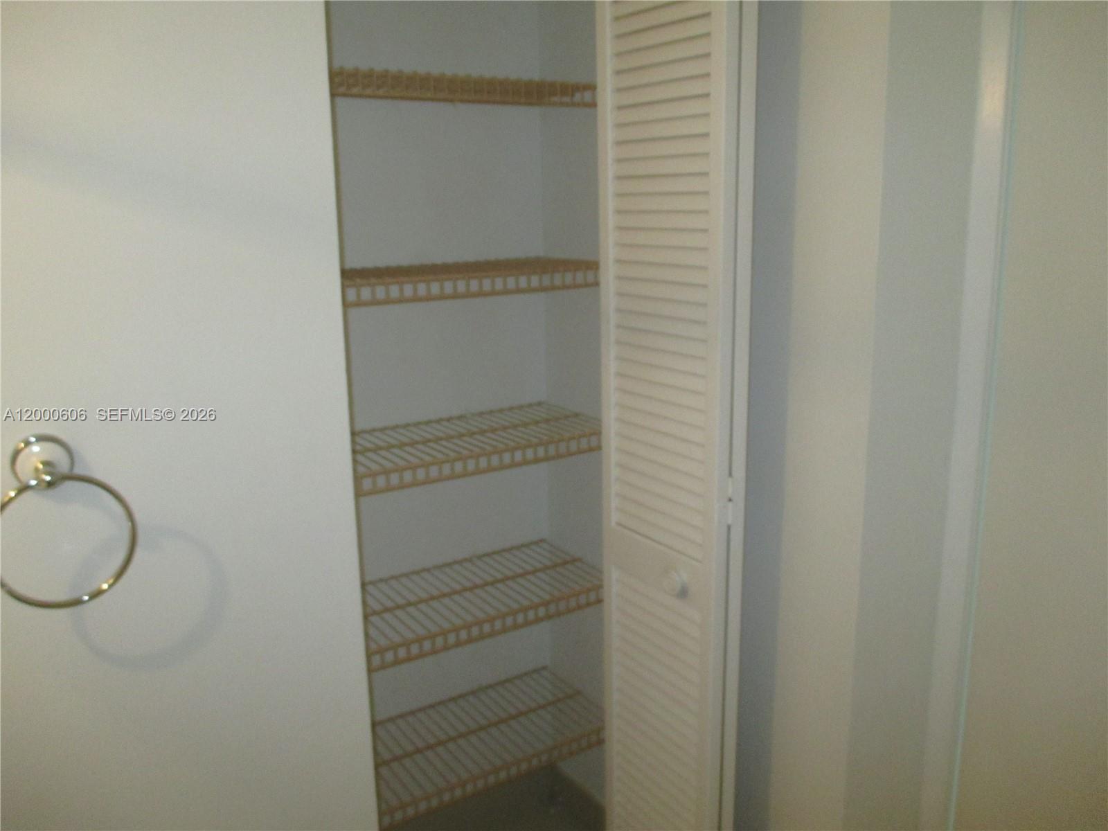 A white closet with louvered doors contains several wire shelves for storage — 1865 Brickell Ave # A1207, Miami FL 33129, MIAMI, FL