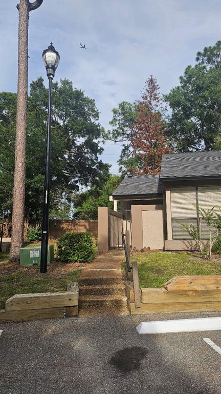 An exterior view of a building entrance with a lamp post, stairs, and landscaping — 940 DOUGLAS AVENUE UNIT 212, ALTAMONTE SPRINGS, FL
