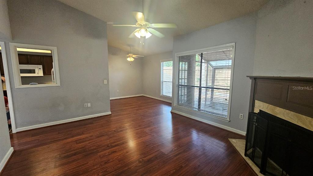 A living room features wood-look flooring, a fireplace, and a ceiling fan — 940 DOUGLAS AVENUE UNIT 212, ALTAMONTE SPRINGS, FL