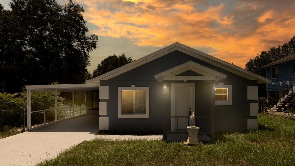 A single-story gray house with a white-trimmed window and a covered carport at sunset — 31128 LOCHMORE CIRCLE, SORRENTO, FL