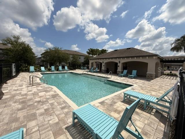 A living room features a white sofa, two blue armchairs, and a wood coffee table — 11956 SANDS COVE, ORLANDO, FL