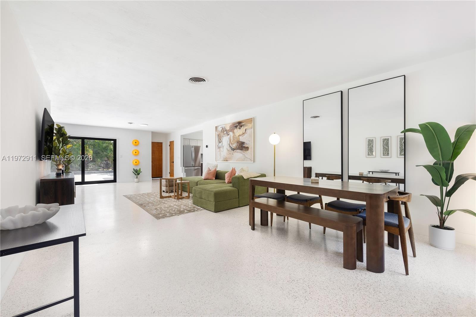A bright, open-concept living and dining area features white terrazzo floors and modern furniture — 1860 SW 13th St, Miami FL 33145, MIAMI, FL