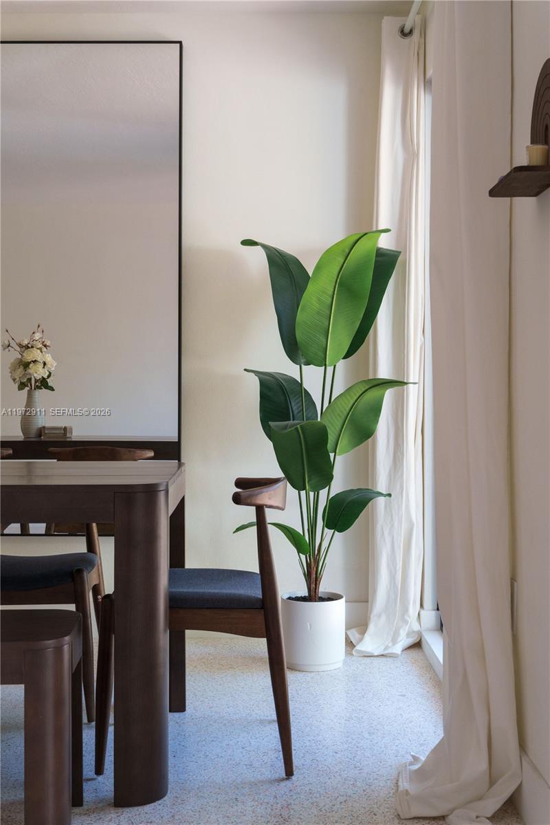 A dining area features a dark wood table, modern chairs, and a large potted plant — 1860 SW 13th St, Miami FL 33145, MIAMI, FL