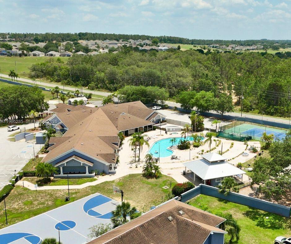 An aerial view shows a community clubhouse with a swimming pool, tennis court, and basketball court — 515 ORCHID DR, Davenport FL 33897, DAVENPORT, FL