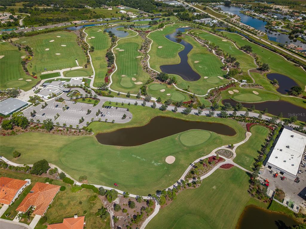 An aerial view of a golf course with a clubhouse, parking lot, and surrounding homes — 24459 SW KINGSWAY CIRCLE, ARCADIA, FL