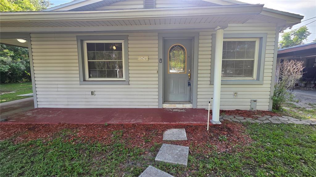 A single-story house exterior features light gray siding, a front porch, and a gray door — 1636 TERRY ROAD, LAKELAND, FL