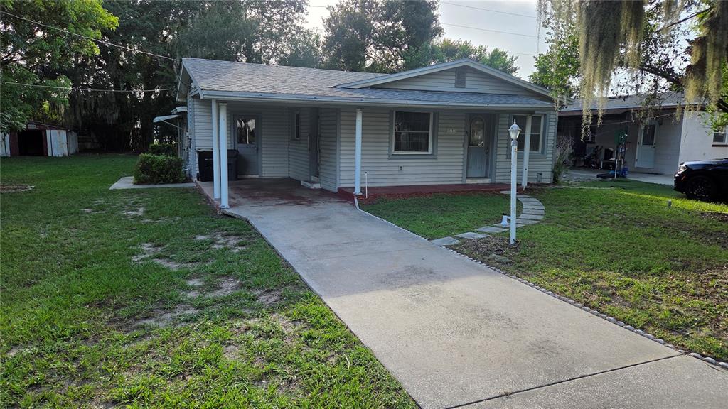 A single-story house with light gray siding, a carport, and a concrete driveway — 1636 TERRY ROAD, LAKELAND, FL
