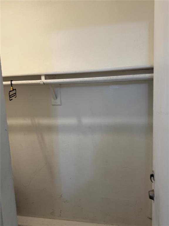 A small, empty closet features a white shelf and a metal clothing rod — 2512 LEMON TREE LANE UNIT 3C, ORLANDO, FL