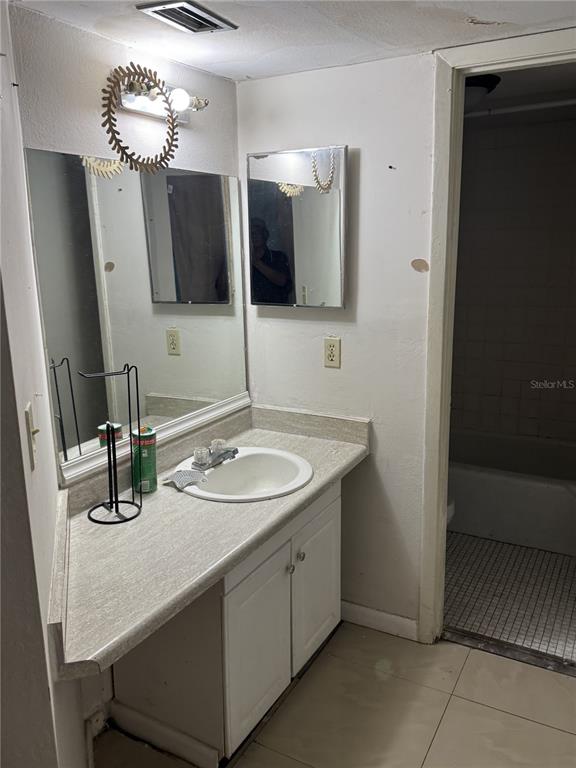 A bathroom features a vanity with a white sink, a mirror, and a tiled floor — 2512 LEMON TREE LANE UNIT 3C, ORLANDO, FL