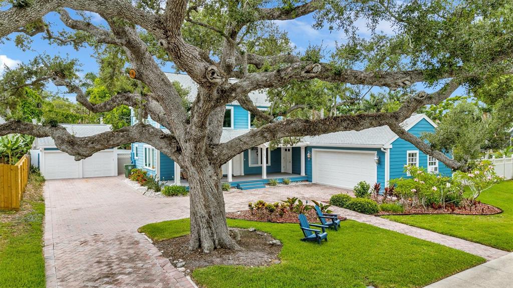 A blue two-story house with a large oak tree and a brick driveway — 206 20TH STREET W, BRADENTON, FL