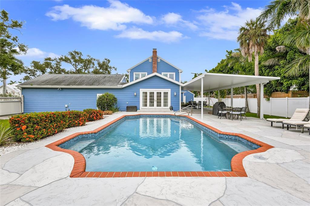 A blue house with a swimming pool and a covered patio in the backyard — 206 20TH STREET W, BRADENTON, FL