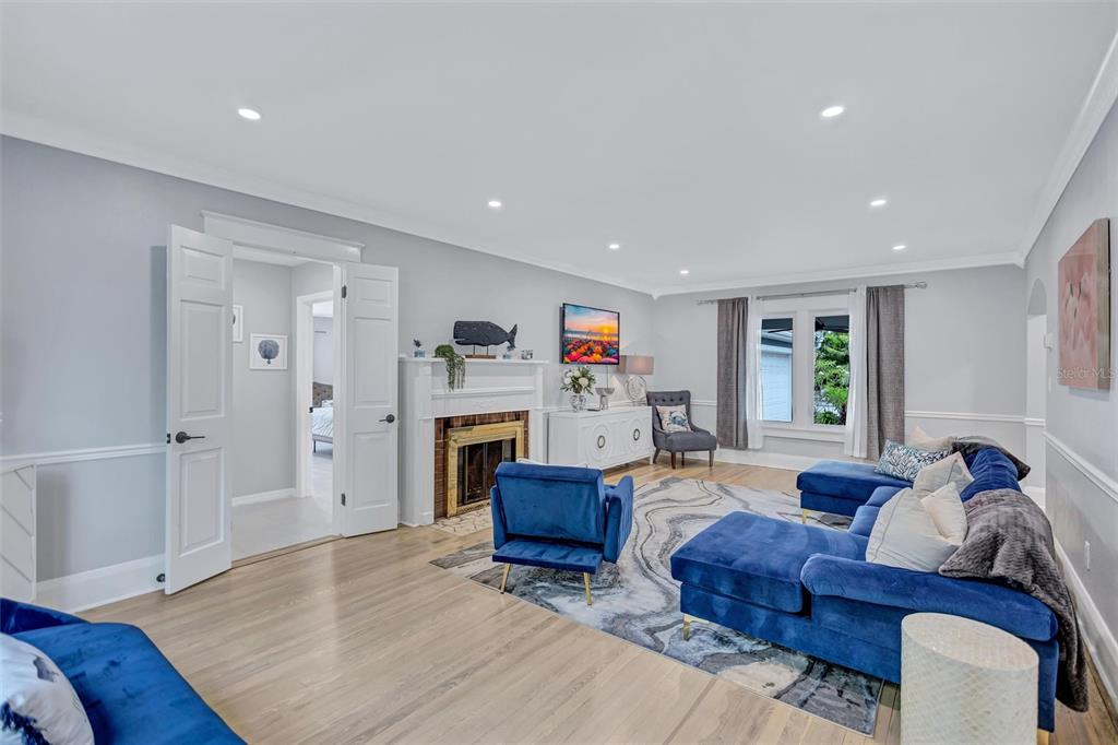 A living room features a fireplace, blue sectional sofa, armchair, and light hardwood flooring — 206 20TH STREET W, BRADENTON, FL