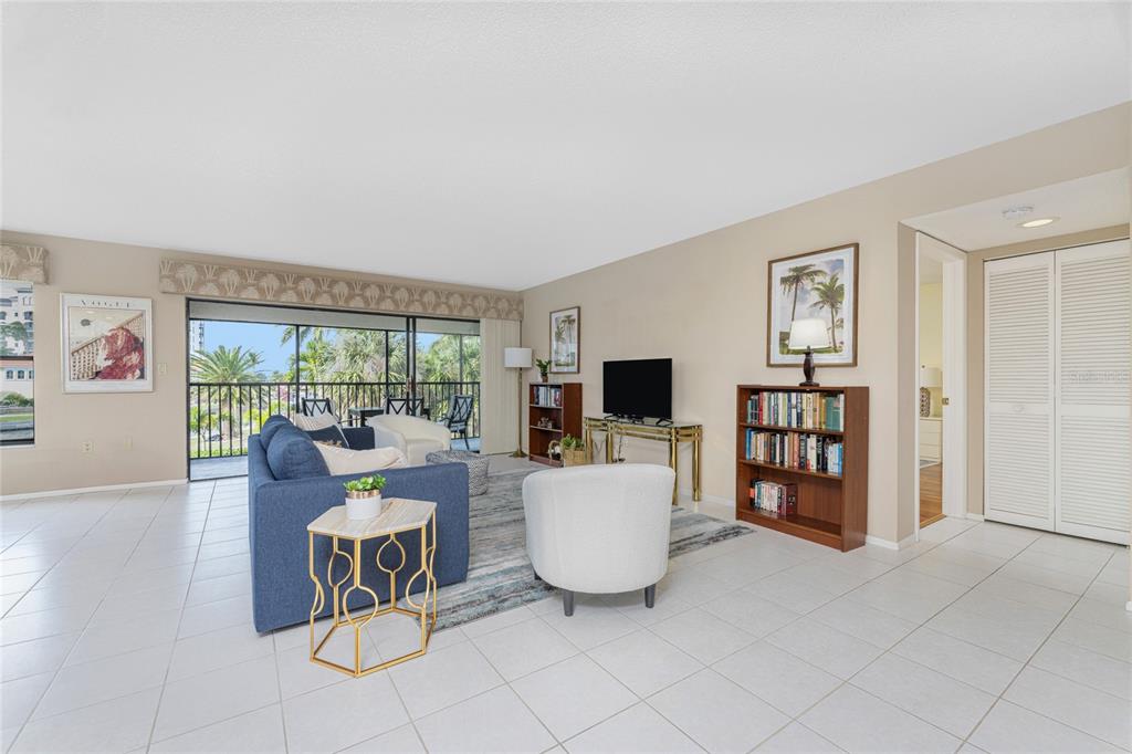 A living room features tile flooring, a blue sofa, a bookshelf, and a balcony view — 3265 SUGARLOAF KEY ROAD UNIT 43B, PUNTA GORDA, FL