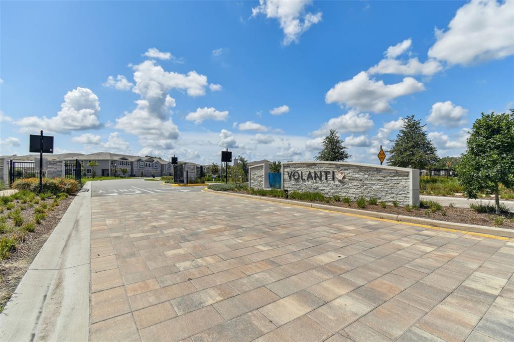 The entrance to the Volanti community features a stone monument sign and paved driveway — 4286 CLOUD HOPPER WAY, LUTZ, FL