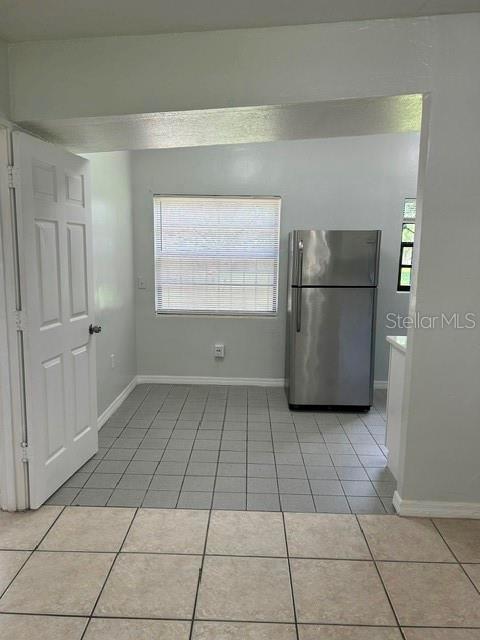 A kitchen with light gray walls, a stainless steel refrigerator, and light-colored tile flooring — 1915 MORNING DRIVE, ORLANDO, FL