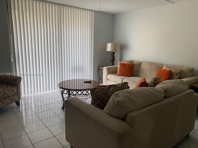 A living room features a beige sofa, a round coffee table, and vertical window blinds — 5530 NW 44th St # 111C, Lauderhill FL 33319, LAUDERHILL, FL