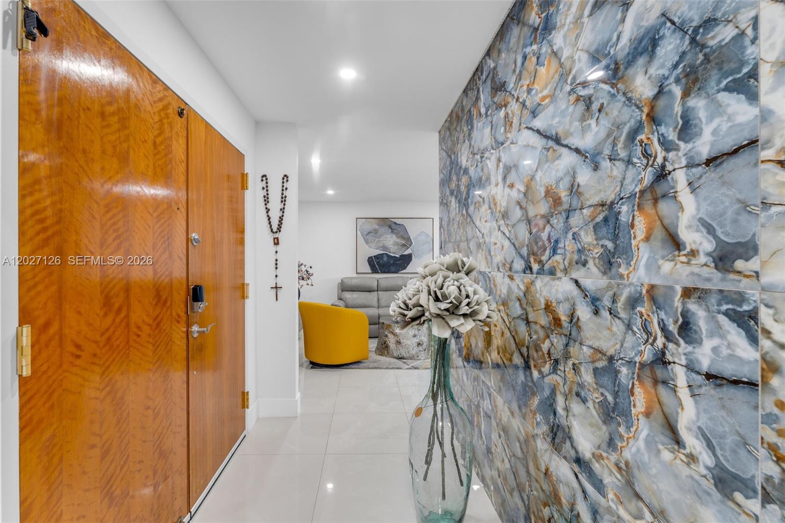 A hallway features a wood door, a blue marble-patterned accent wall, and a floral centerpiece — 1350 SW 122nd Ave # 415, Miami FL 33184, MIAMI, FL
