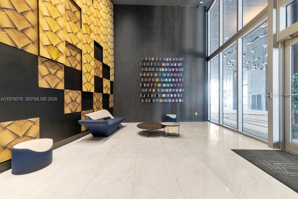 A modern lobby features a patterned gold wall, dark accent wall, and contemporary seating — 3900 Biscayne Blvd # 1101, Miami FL 33137, MIAMI, FL
